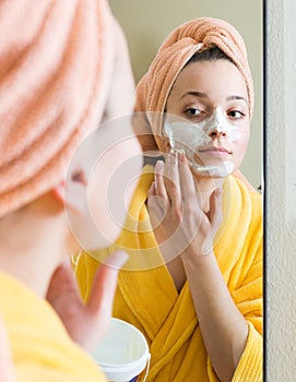 Girl applying cream on skin