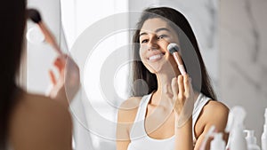 Girl Applying Face Powder Using Makeup Brush Standing In Bathroom