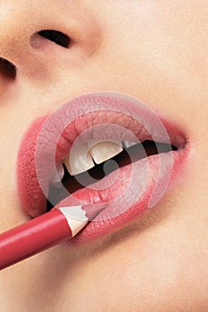 Girl applying lip liner photo