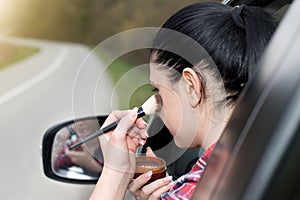 Girl applying makeup in car