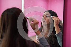 girl applying mascara to eyelashes