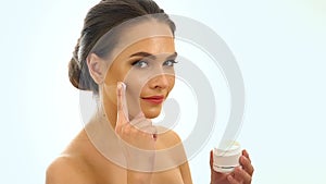 Girl applying moisturizer on your face. Slow motion.