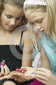 Girl Applying Nail Polish To Friend's Fingernails