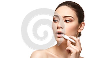 Girl applying pink lipstick isolated on white