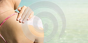 Girl applying sun lotion on the beach