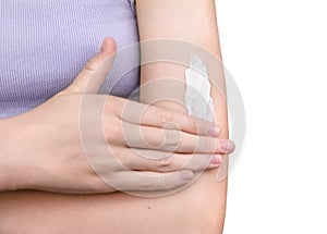 A girl applying sunscreen isolated on white background. Woman moisturizing her arm with cosmetic cream. Skincare concept