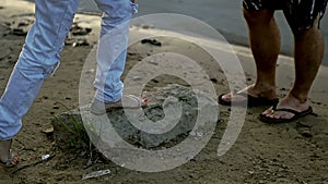 Girl approaches the guy and stands on the stone