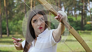 Girl archer moving bow between targets and shoots