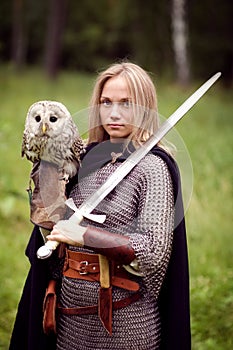 Girl in armor and with a sword holding an owl