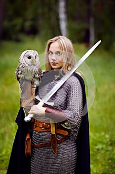 Girl in armor and with a sword holding an owl