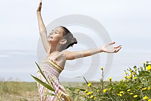 Girl With Arms Outstretched Enjoying Sunlight At Field