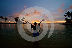 Girl with arms wide open at beach sunset