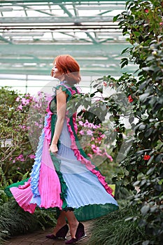 Girl in arranger where azalea blooms in a colorful flying dress photo