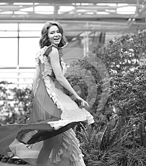 Girl in arranger where azalea blooms in a colorful flying dress photo