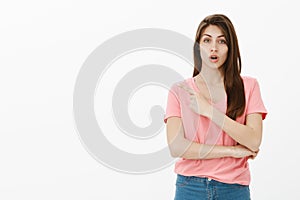 Girl asking advice while pointing at dress she wants to buy. Portrait of good-looking busy young woman in casual outfit