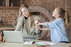 Girl asking her working mom for attention