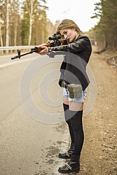 Girl assassin waiting for his victim on the road.