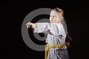 Girl athlete is beating blow hand on a black background