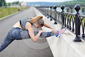 Girl athlete doing sports exercises workout on the waterfront