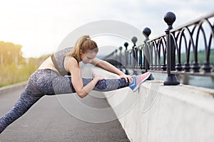 Girl athlete doing sports exercises workout on the waterfront