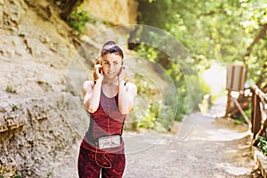 Girl athlete listens to music during a break between workouts. Concept on the topic of a healthy lifestyle