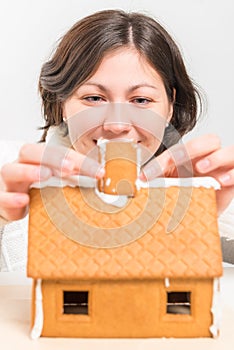 Girl attach a pipe to the gingerbread house