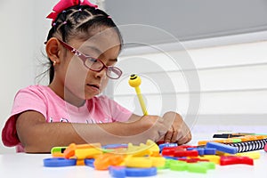 Girl with autism spectrum disorder ASD like Asperger, Rett and Heller draws at a desk, plays with colors alone antisocial