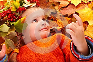 Girl in autumn orange leaf and red berry.