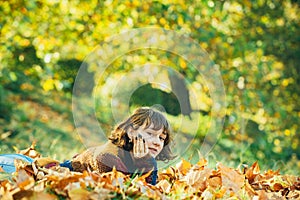 Girl in autumn orange leaves. Seasonal concept. Girl with autumn yellow leaf in sweater. Autumn model. Nice sunny
