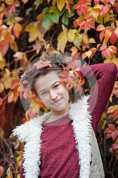 Girl in autumn Park holding yellow maple leaf in hand.