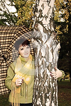 The girl in autumn park with an umbrella.