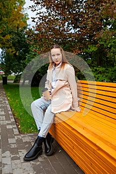 Girl in  autumn raincoat in  park on  sunny day