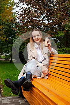Girl in  autumn raincoat in  park on  sunny day