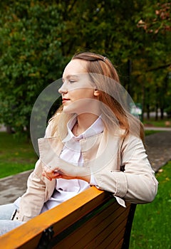 Girl in  autumn raincoat in  park on  sunny day