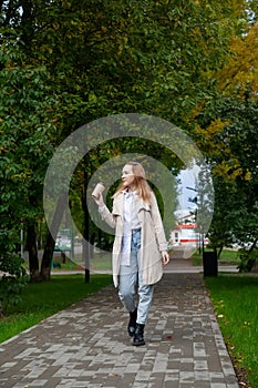 Girl in  autumn raincoat in  park on  sunny day