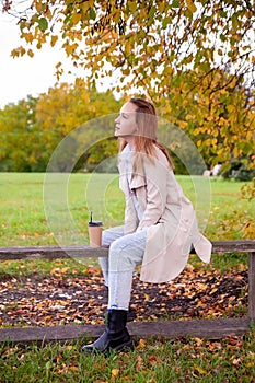 Girl in  autumn raincoat in  park on  sunny day