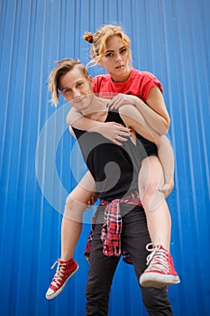 Modern and stylish hipsters couple on blue background, sunny portrait couple teenagers.