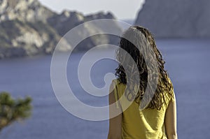 Girl back near sea and island alone.