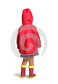 Girl is back in rubber boots and a raincoat isolated on white