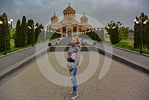 A girl in the background of the Church of St. Gregory the Illuminator in the center of Yerevan, May 2, 2019. Armenia.