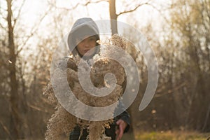 A girl on the background of reeds in the field, holding branches of reeds in her hand.