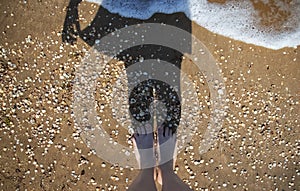 Girl on a background of the sea. Shadow and reflection of a woman`s dress on a sunny beach. The concept of lifestyle, rest and rel