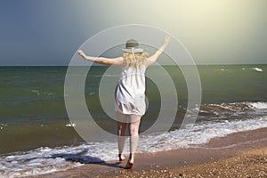 Girl on a background of the sea. Shadow and reflection of a woman`s dress on a sunny beach. The concept of lifestyle, rest and rel photo