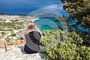 A girl on the background of a view from the Genoese fortress to the Sudak Bay. Sudak May 2021.