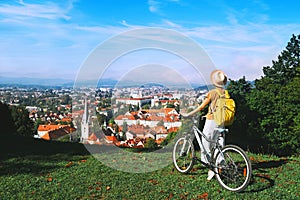 Girl with backpack and bicycle explores Ljubljana. Travel Slovenia