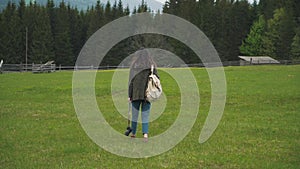 Girl with backpack and camera walking near the forest