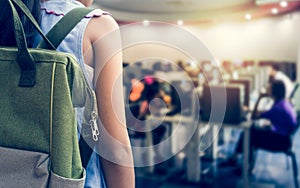 Girl with backpack entering to computer classroom.