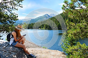 Girl with backpack hiking in mountains on a summer vacation trip.