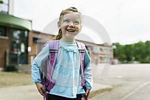 girl with backpack is ready for her first day of school.