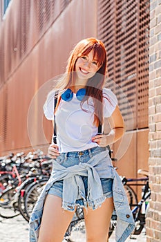 Girl with backpack stands near bicycle parking